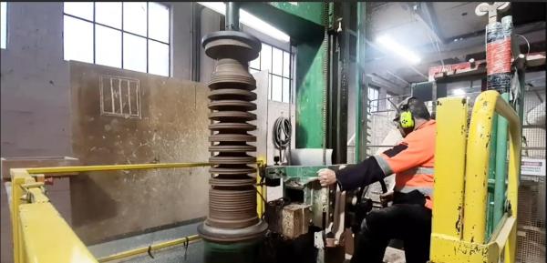 Evan manually controls the Savage Lathe to turn 110kV Insulators